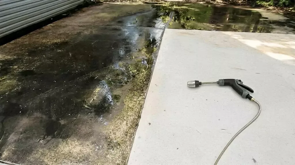 Jetterix test on a narrow concrete strip with years of algae buildup — clear cleaned line through the dirty area